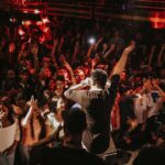 Rap artist performing to a crowd.