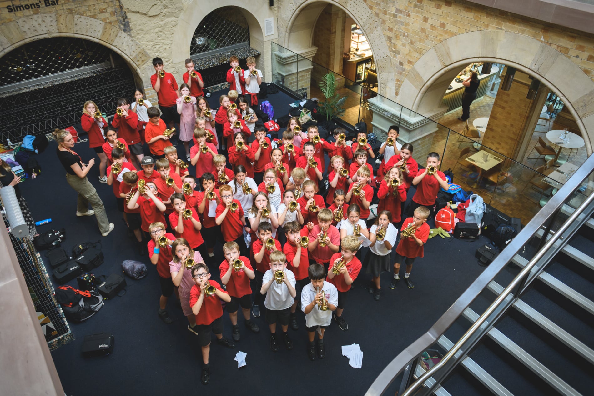 Junior Brass ensemble raise small trumpets in a group
